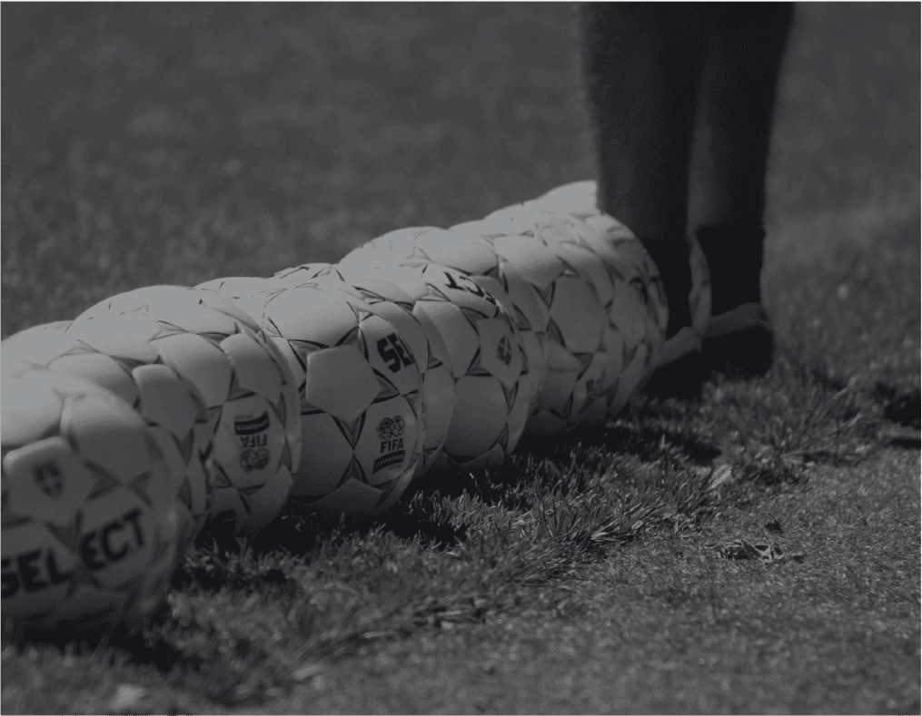 Balones de fútbol alineados en el césped durante un entrenamiento